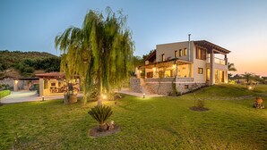 A modern house with a stone facade, a covered patio, and a well-maintained lawn. - Four-Bedroom Private Family Villa with Pool, 400m from the Beach. Villa Russelia (Kamiros skala)