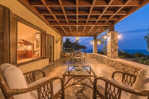 An outdoor patio with a table and chairs, overlooking a scenic view. - Four-Bedroom Private Family Villa with Pool, 400m from the Beach. Villa Russelia (Kamiros skala)