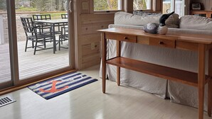 Un interior de madera con un sofá, una mesa y vistas al exterior.