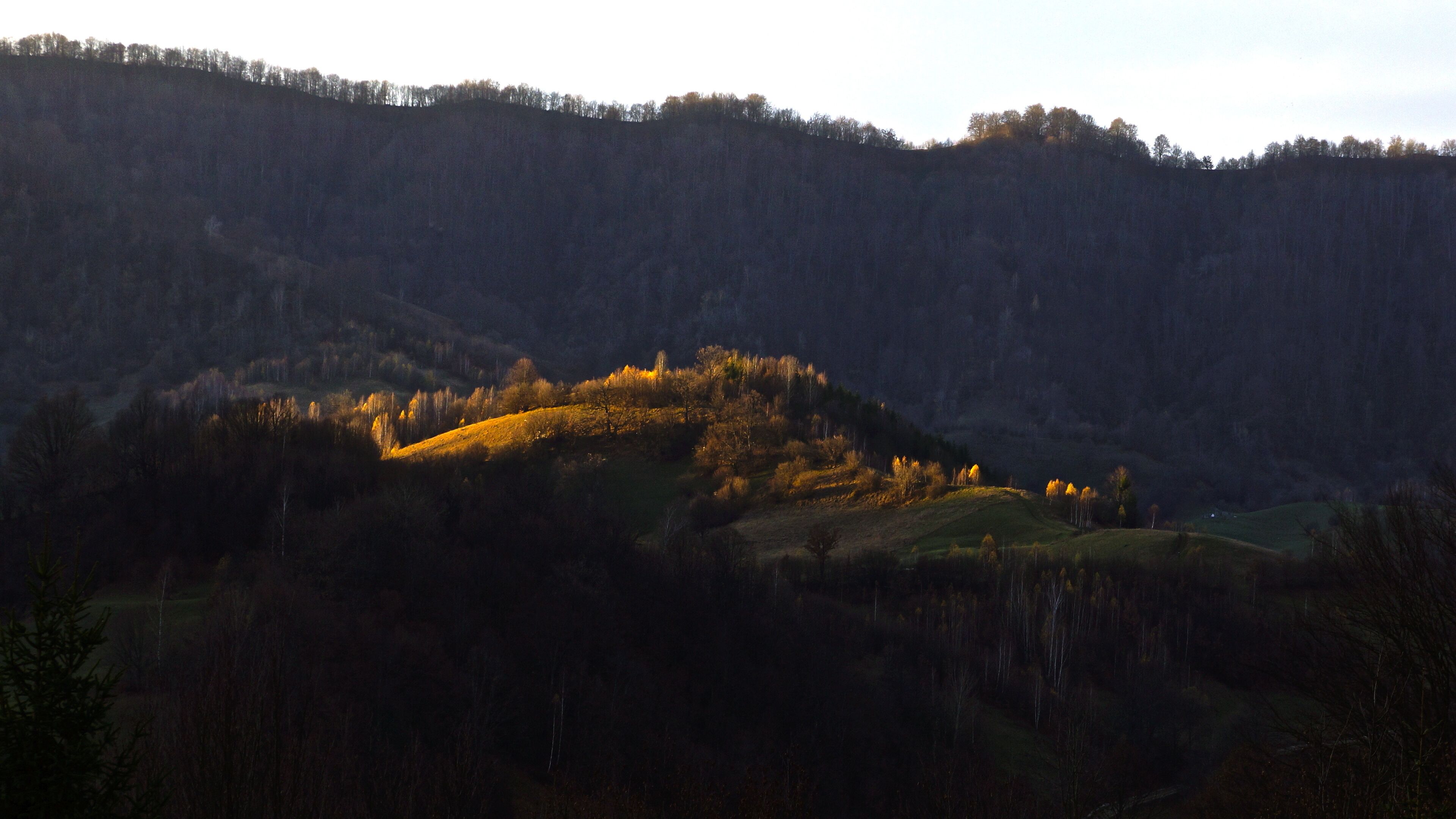 A hilly landscape with a small village nestled in the valley.