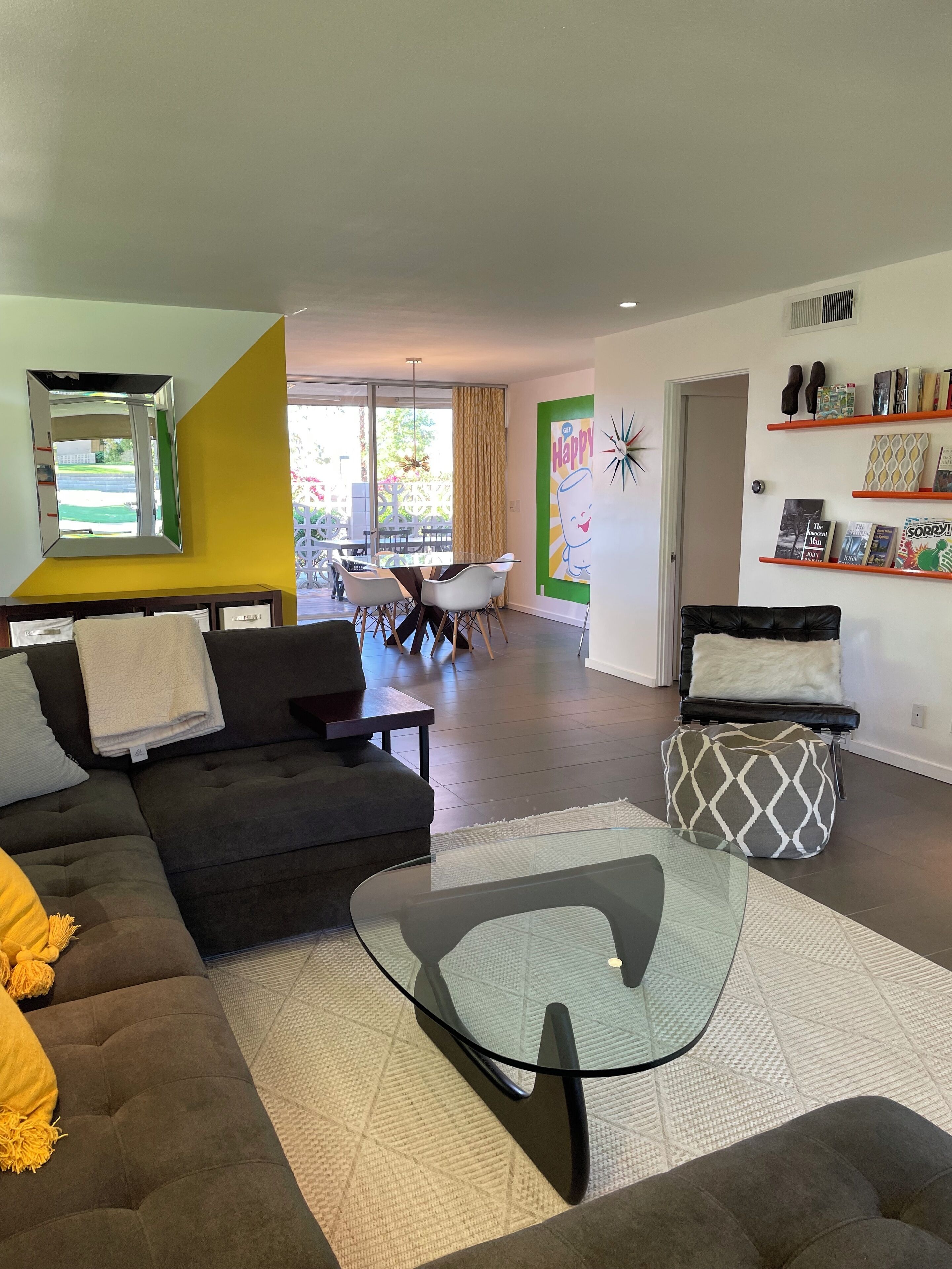 Un salon moderne avec un canapé, une table basse en verre et un coin repas avec des chaises.