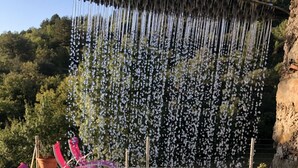 A pool area with a water feature and lounge chairs.