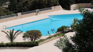 Une piscine avec vue sur la mer et la végétation environnante.