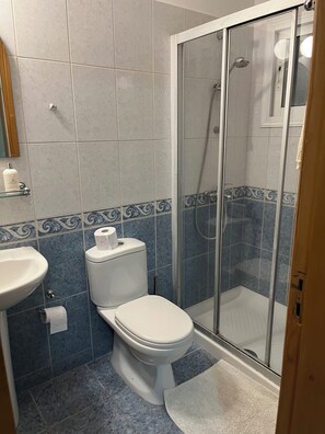 Een bad/douchecombinatie, een haardroger, handdoeken