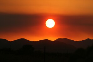 Un atardecer sobre montañas con cielo despejado.