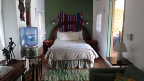 A bedroom with a bed, a water dispenser, a lamp, and a chair. - Casa de Como Casita #2 - Ajijic Village (Ajijic)