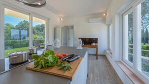 A modern kitchen with large windows, a wooden countertop, and stainless steel appliances. - Tenuta Bellosguardo on the hills with Swimming pool and Jacuzi! EXCLUSIVE ESTATE (Lucca)