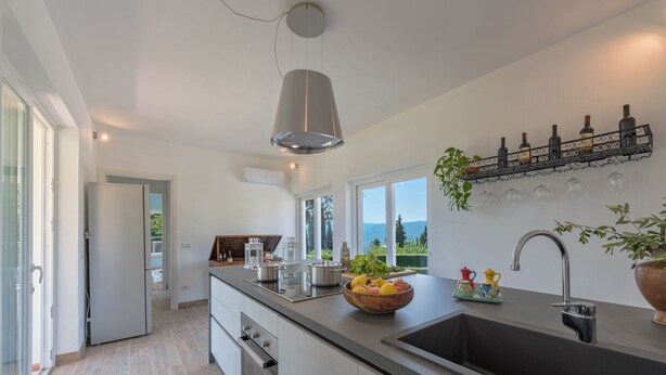 A modern kitchen with a large island, a built-in oven, and a view of the outdoors. - Tenuta Bellosguardo on the hills with Swimming pool and Jacuzi! EXCLUSIVE ESTATE (Lucca)
