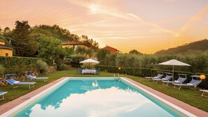 A rectangular swimming pool with lounge chairs and umbrellas, surrounded by greenery and hills. - Tenuta Bellosguardo on the hills with Swimming pool and Jacuzi! EXCLUSIVE ESTATE (Lucca)