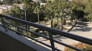 A balcony with a metal railing overlooking a residential area with houses, trees, and a clear sky. - Outstading Executive Apartment 150 metres from the beach (Albufeira)