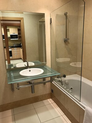 Een bad, een bidet, handdoeken, toiletpapier