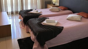 A hotel room with two beds, a nightstand, a lamp, and a view of the city through sheer curtains. - Outstading Executive Apartment 150 metres from the beach (Albufeira)