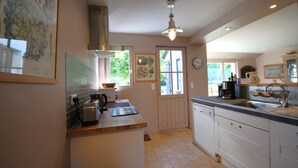 A kitchen with a wooden countertop, white cabinets, a sink, and a window with a view of greenery. - 4* listed house with large private garden in a 6-hectare estate (Bangor)