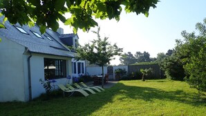 A house with a white exterior, a tiled roof, and a grassy backyard with a few potted plants and a small tree. - 4* listed house with large private garden in a 6-hectare estate (Bangor)