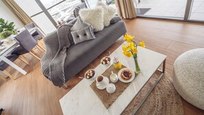 A modern living room with a sofa, coffee table, and breakfast setup. - Sky Homes on Queen (Brisbane)