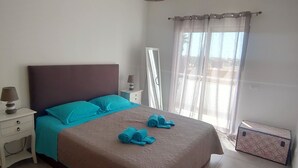 Une chambre à coucher avec un lit, une table de chevet, une lampe et une valise.