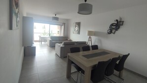 Un salon moderne comprenant un coin repas, un canapé, une table basse et une lampe.