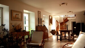 Un salón comedor amplio con una escalera de madera, una mesa de comedor y asientos cómodos.