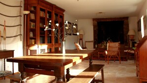 Un salón tradicional con una mesa de centro de madera, una estantería y una mesa de comedor.