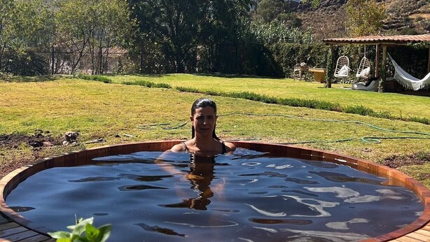A person in a hot tub with a mountainous landscape in the background. - Luxury house in Sacred Valley. Modern comfort, rustic style, stunning views (Urquillos Urubamba)