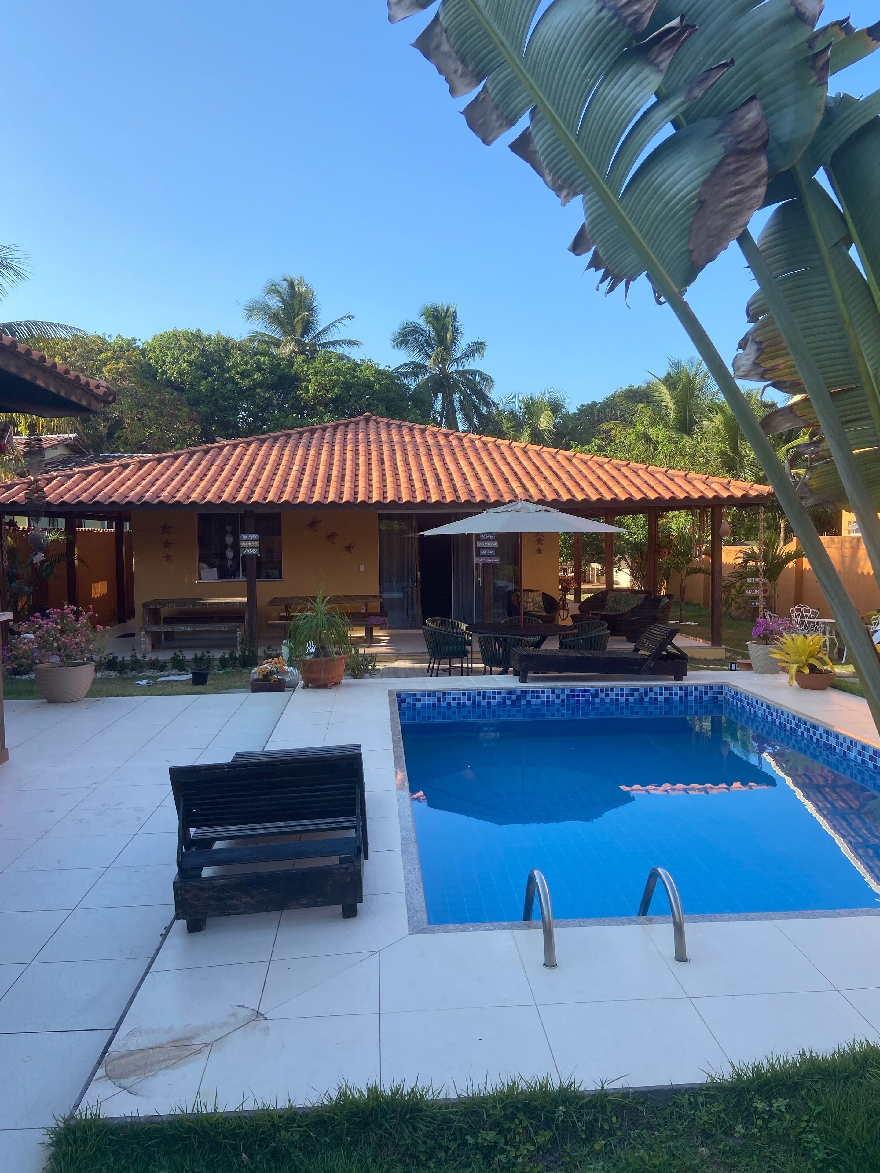 Un espace piscine doté d’une terrasse carrelée, d’un banc et d’une petite piscine.