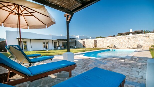 A pool area with lounge chairs and an umbrella. - Villa Olympos close to Anthony Quinn Bay (rhodes)