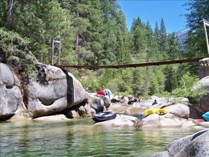Ein Fluss mit Steinen und einer Brücke.