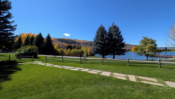 Un parque con un lago, senderos para caminar y árboles.