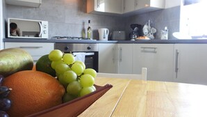 A kitchen with a wooden table, a microwave, and cabinets.