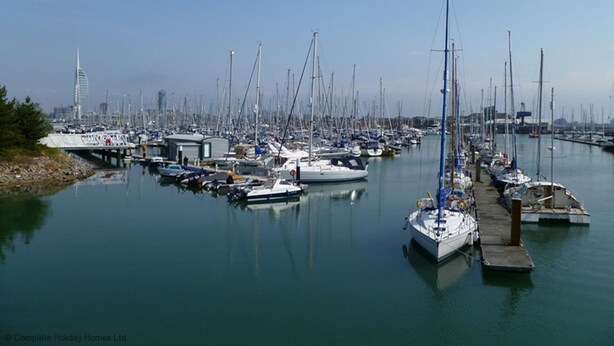 A marina with numerous sailboats docked at piers.