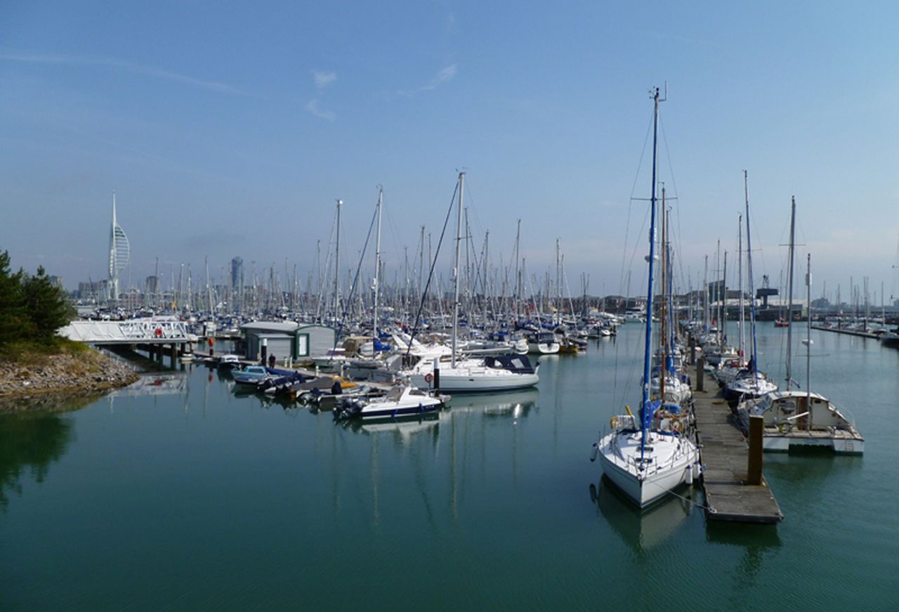 Un puerto deportivo con numerosos veleros amarrados a los muelles.