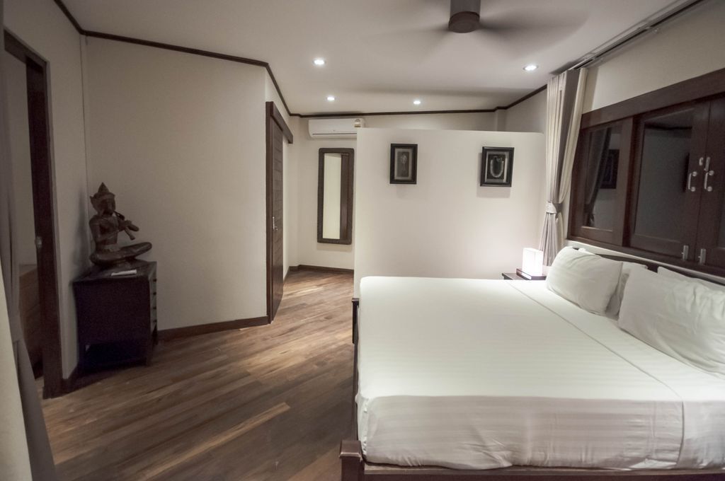 Una camera da letto con un letto grande, un comodino, una statua e un armadio.