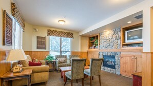 A cozy living room with a fireplace, comfortable seating, and a television.