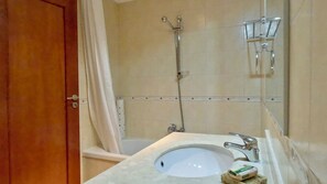 Une salle de bain avec une douche, un lavabo et un miroir.