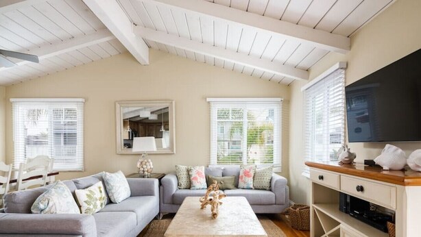 A living room with a grey sofa set, a coffee table, a TV, and a cabinet.