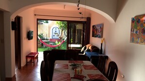 A dining area with a table set for four, a hammock outside, and a view of a garden. - Apartamentos los Nazarenos PRIVATE APT 4 - heated swimming pool, jacuzzi and gym (Antigua Guatemala)