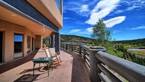 A balcony with a table and chairs, overlooking a scenic landscape with hills and a river. - Beautiful Lodge and Private 600 acre Canyon Paradise (Altamont)