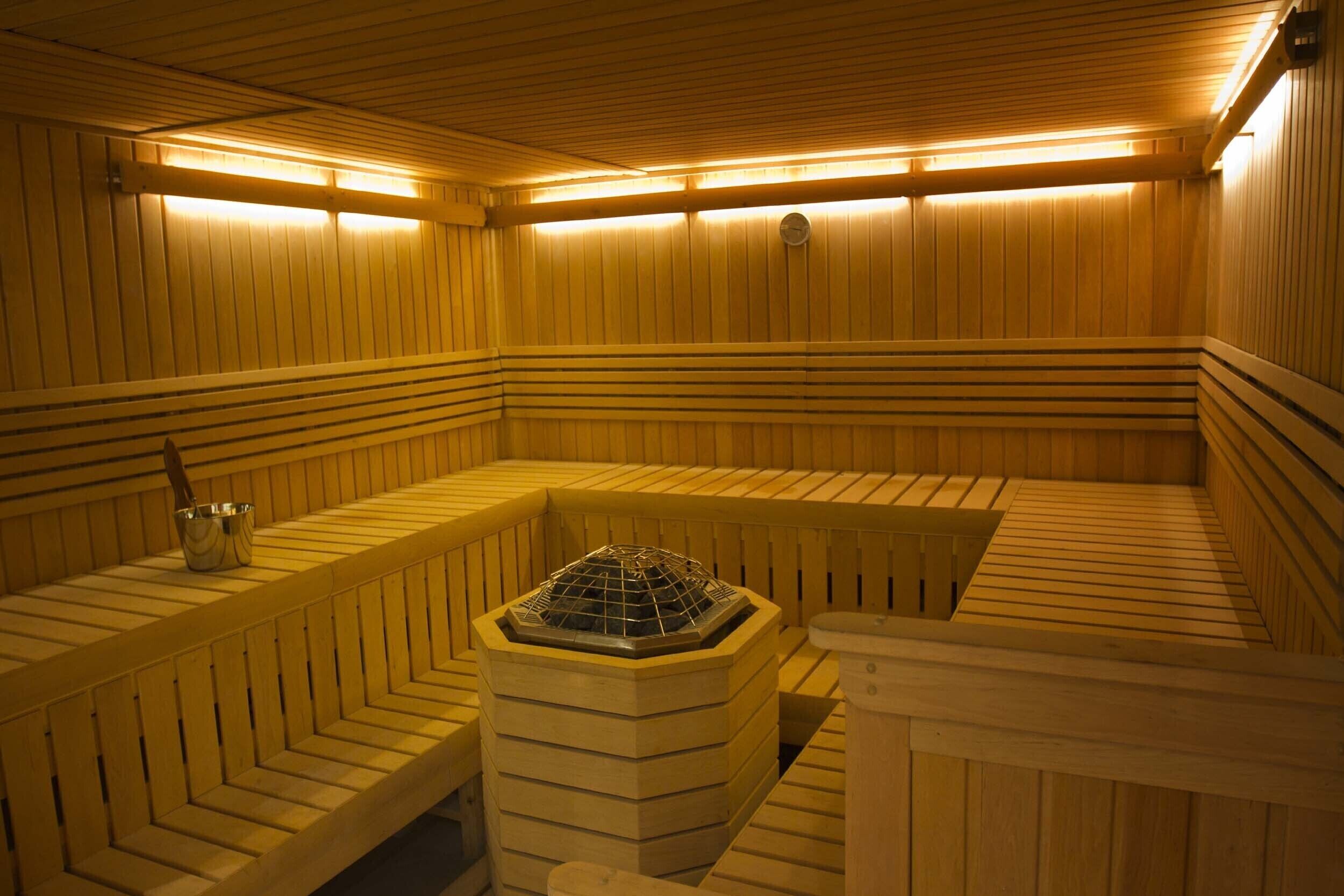 Un sauna avec des bancs en bois et un système de chauffage central.