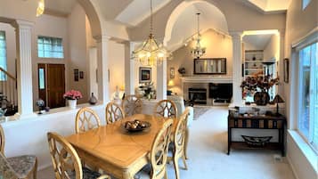Experience a luxurious dining area with a grand chandelier, fireplace, and elegant console table.
