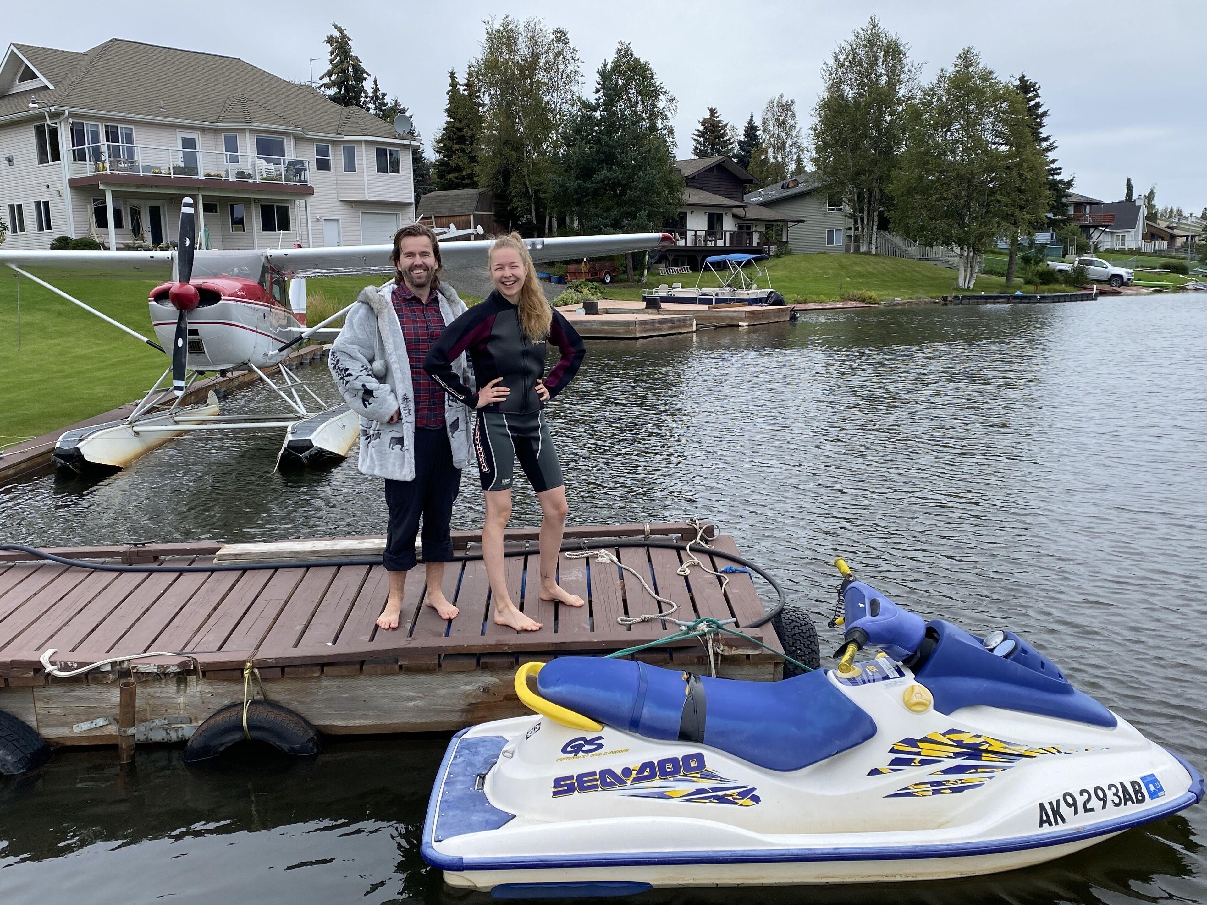 A wooden dock with a jet ski and a small aircraft.