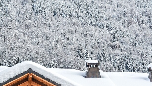 A wooden chalet with a balcony, surrounded by snow-covered trees. - Light airy Chalet - Mountain And Waterfall Views. Excellent access all Amenities (Samoëns)