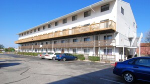 Een motel met meerdere verdiepingen en een parkeerplaats.
