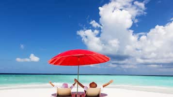 Na praia, espreguiçadeiras, toalhas de praia