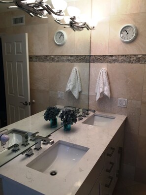 Een bad/douchecombinatie, een haardroger, handdoeken, zeep