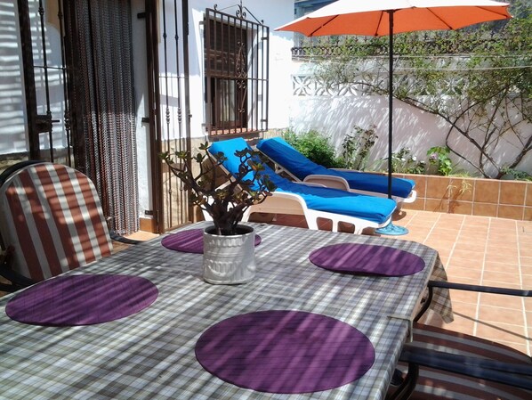 A patio with a checkered tablecloth, purple cushions, and a potted plant. - VILLA WITH POOL SEASIDE (NERJA)