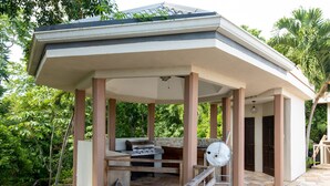 A covered outdoor kitchen area with a grill, sink, and seating. - Relax and enjoy breath taking ocean views from one of Tobago's premier villas! (Mount Irvine, Tobago)