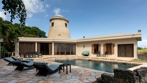 A modern house with a swimming pool, stone patio, and a tower. - Relax and enjoy breath taking ocean views from one of Tobago's premier villas! (Mount Irvine, Tobago)