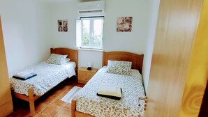 A small, clean room with two single beds, a window, and a door. - Family-friendly Cottage With Pool In Stunning Location (Alvorge)