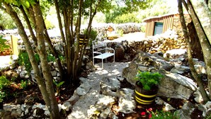 A garden with stone walls, potted plants, and a white bench. - Family-friendly Cottage With Pool In Stunning Location (Alvorge)