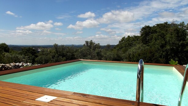 A rectangular swimming pool with clear blue water, surrounded by a wooden deck and metal railings. - Family-friendly Cottage With Pool In Stunning Location (Alvorge)